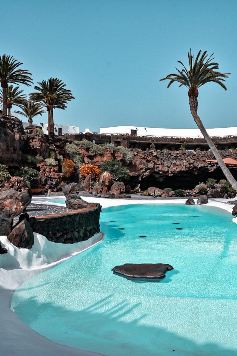 Piscine blanche emblématique entourée de palmiers à Jameos del Agua Lanzarote