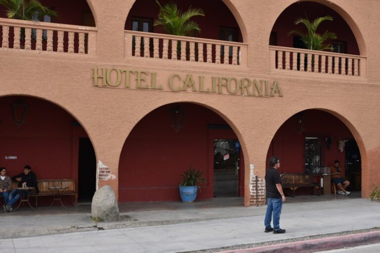 Façade coloniale ocre de l'hôtel California à Todos Santos avec son enseigne mythique