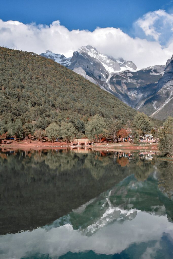 Que faire au Yunnan : mon itinéraire + incontournables 5 Montagne du Dragon de Jade qui se reflète dans l'eau turquoise de la Blue Moon Valley