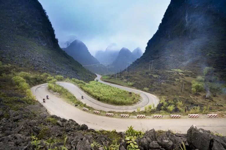Motos qui roulent face au col de Ma Pi Leng sur la Ha Giang Loop