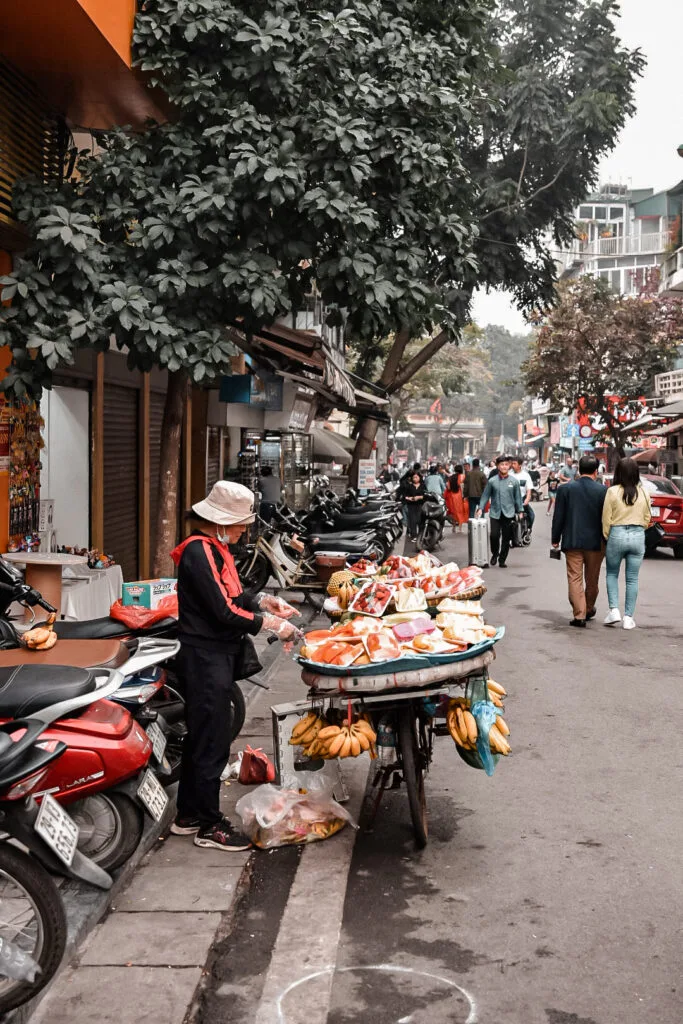 Visiter Hanoï en 2 jours : itinéraire complet ! 9 Stand de rue animé à Hanoï servant des spécialités vietnamiennes locales pour goûter au Vietnam comme un local